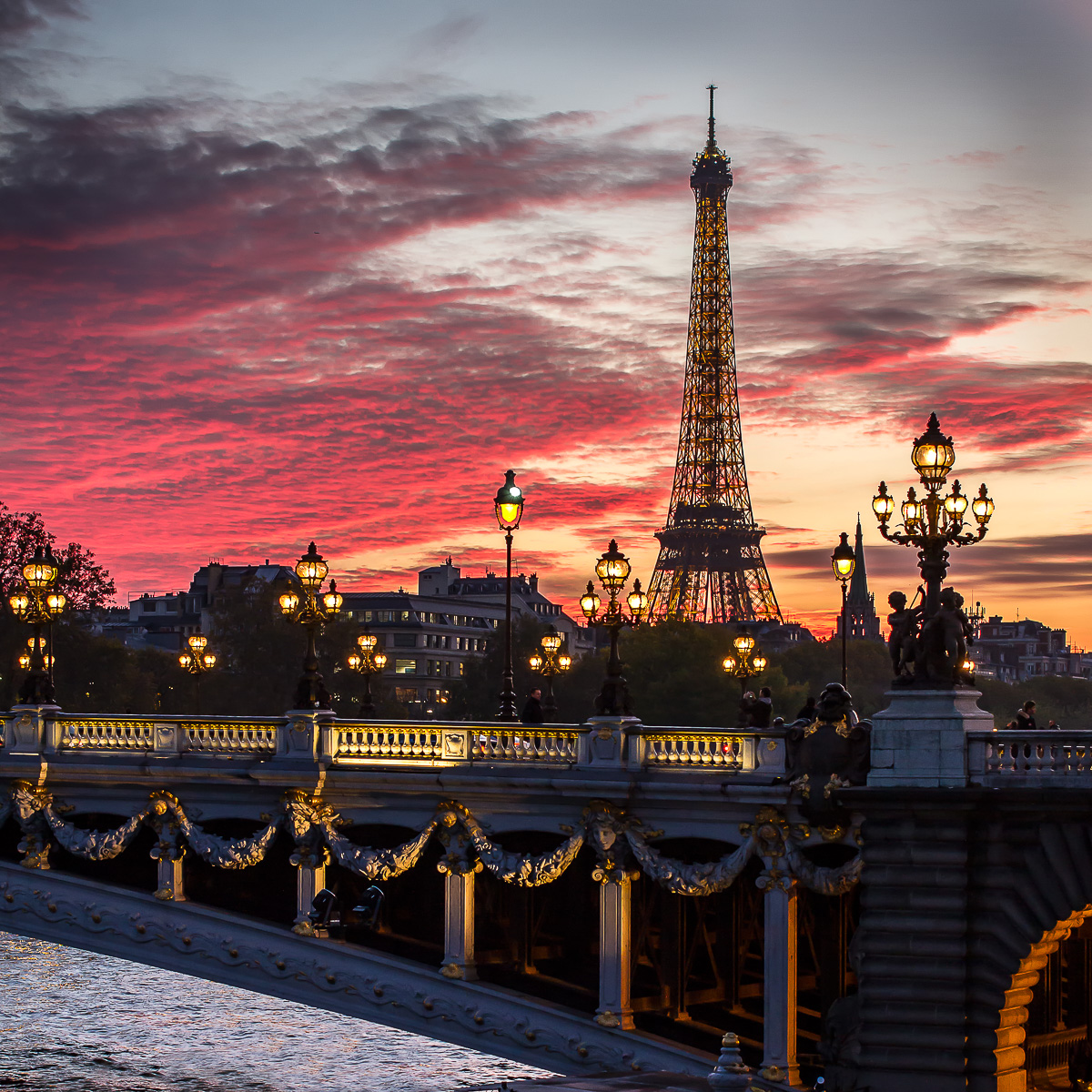 Un soir sur le pont Alexandre à Paris avec la tour Eiffel.